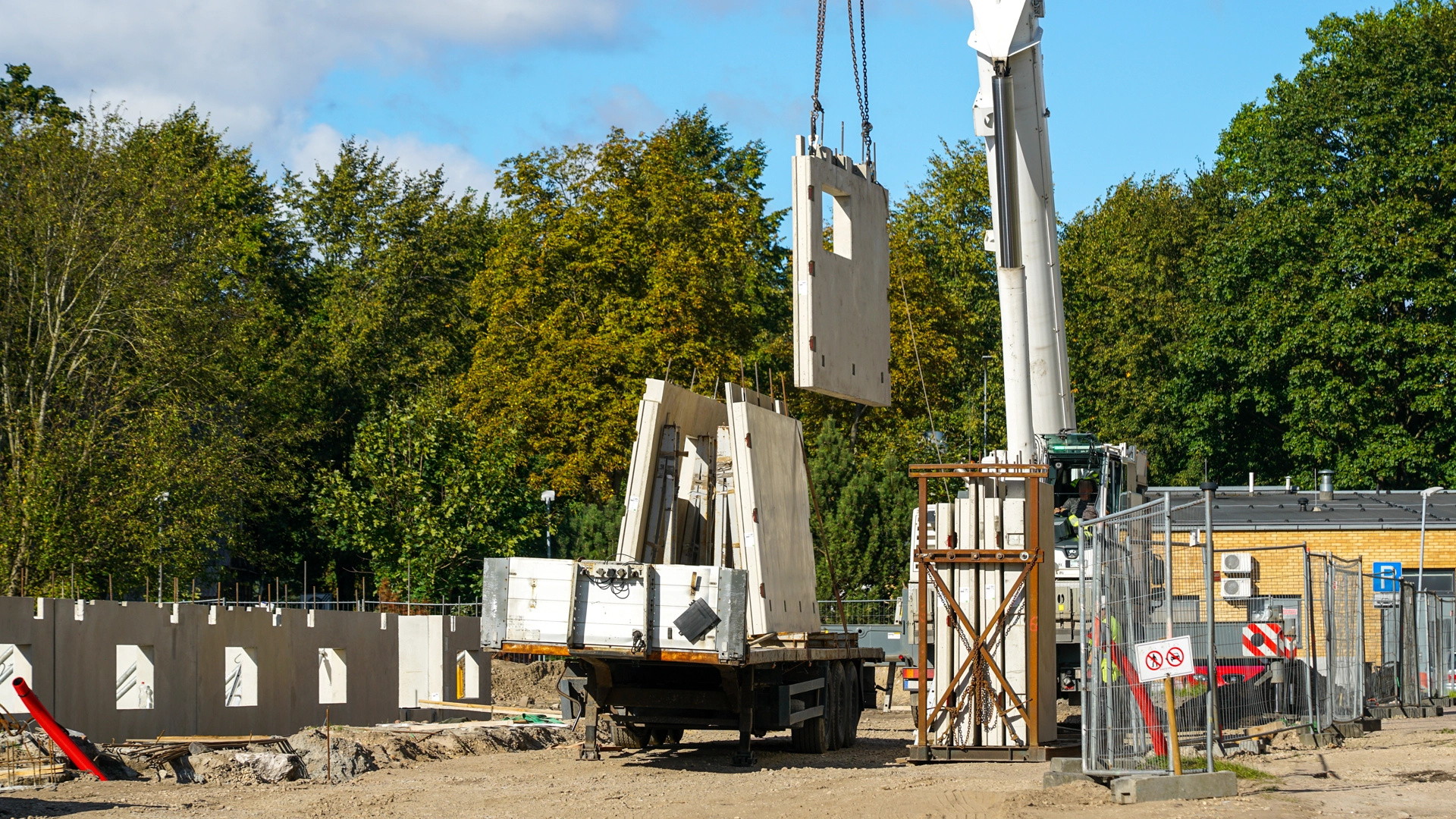 Crane lifting precast concrete wall panels during commercial modular construction in the United States and Puerto Rico