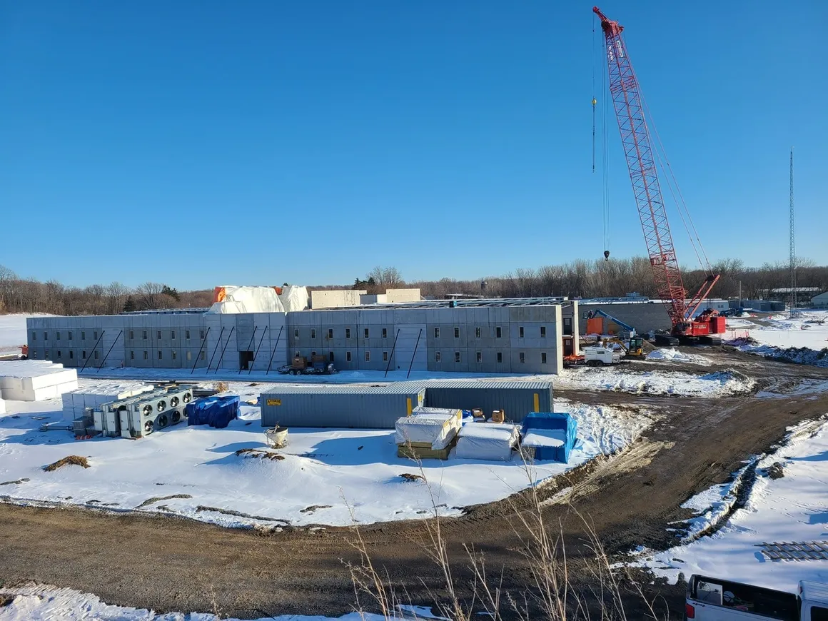 Modular prison cells stacked and aligned during prefabricated prison cell erection by Concrete Erectors, Inc