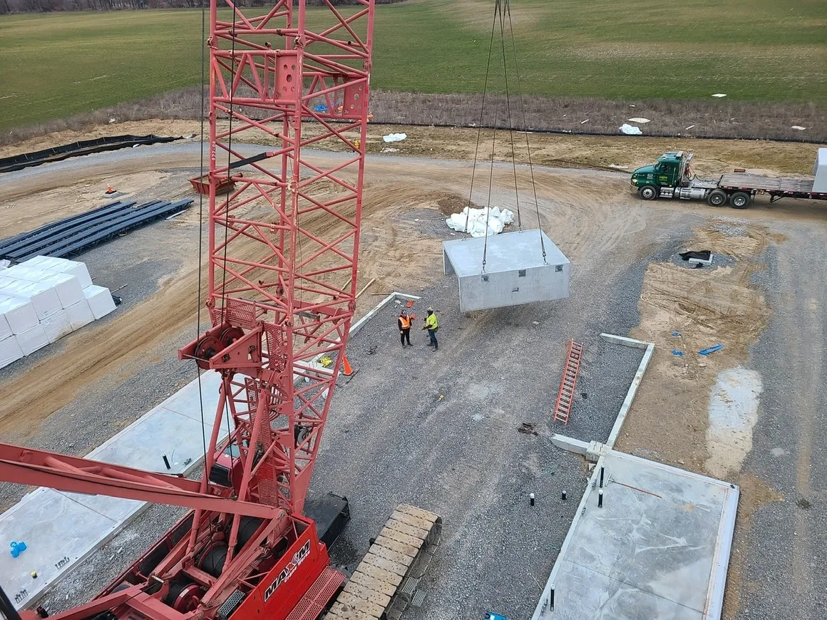 Crane lifting precast concrete structure into place by Concrete Erectors, Inc