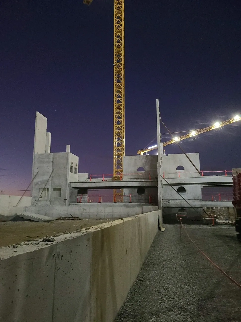 Precast concrete structure installation at night by Concrete Erectors, Inc